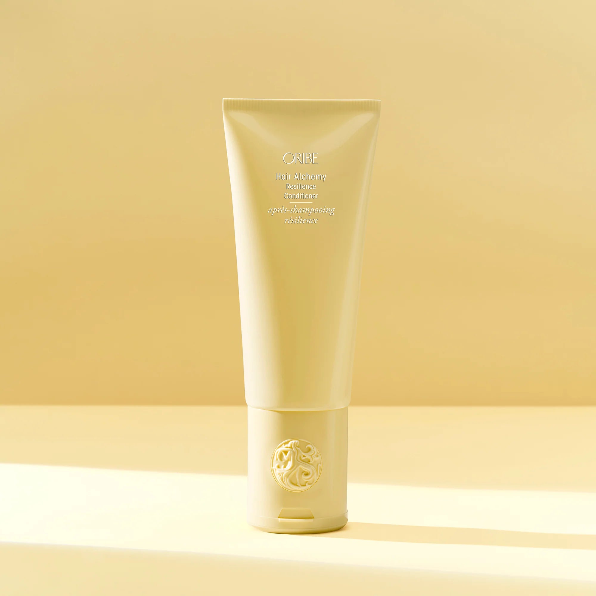 A yellow tube of Oribe Hair Alchemy Resilience Conditioner.