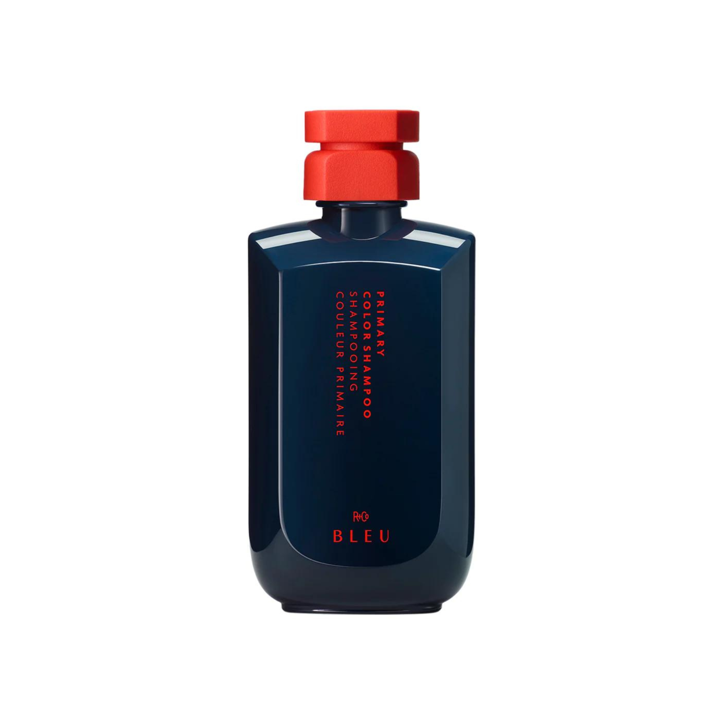 A bottle of R+Co BLEU Primary Color Shampoo with vibrant blue packaging and a red cap.