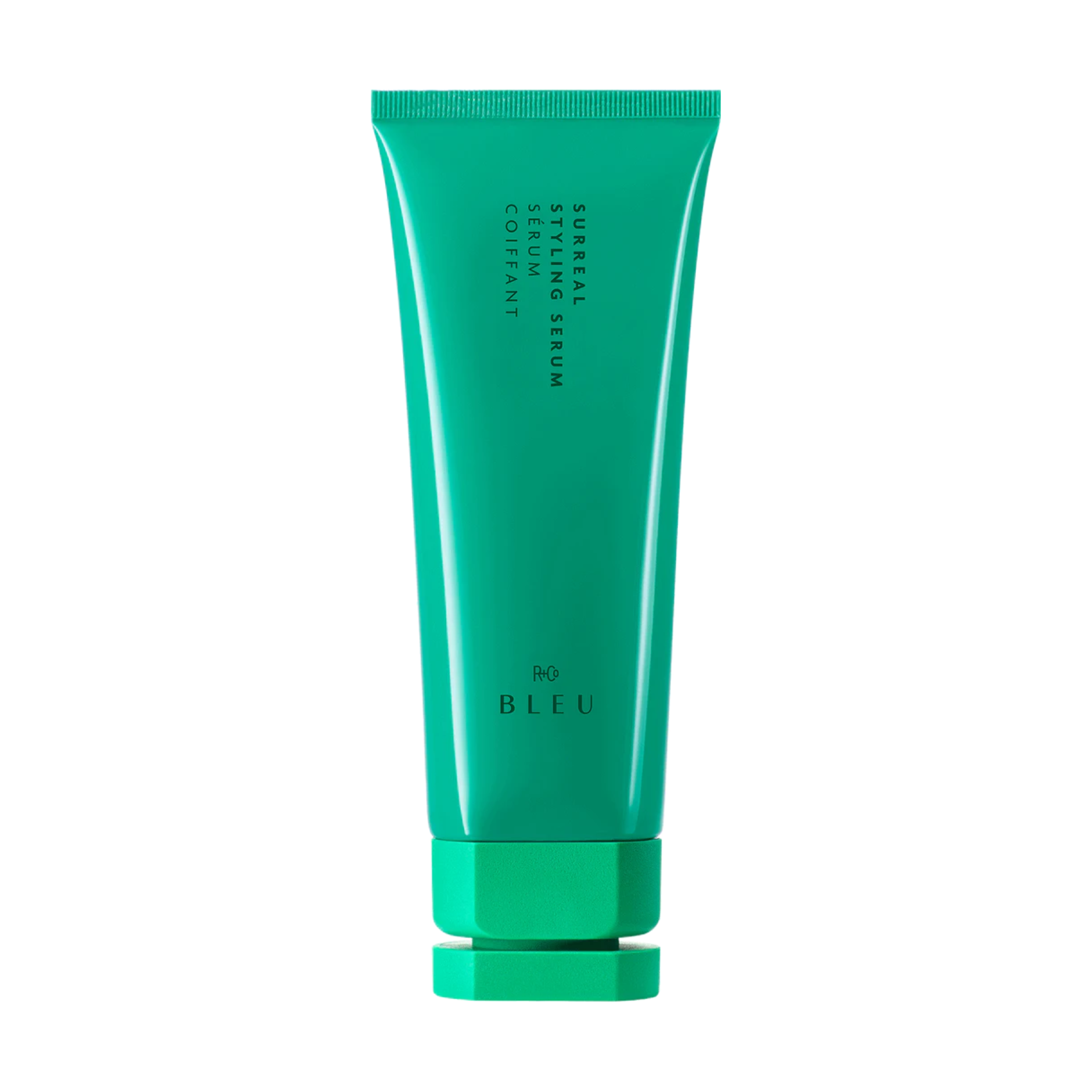 A green tube of Surreal Styling Serum by r+co bleu with a sleek and modern design.