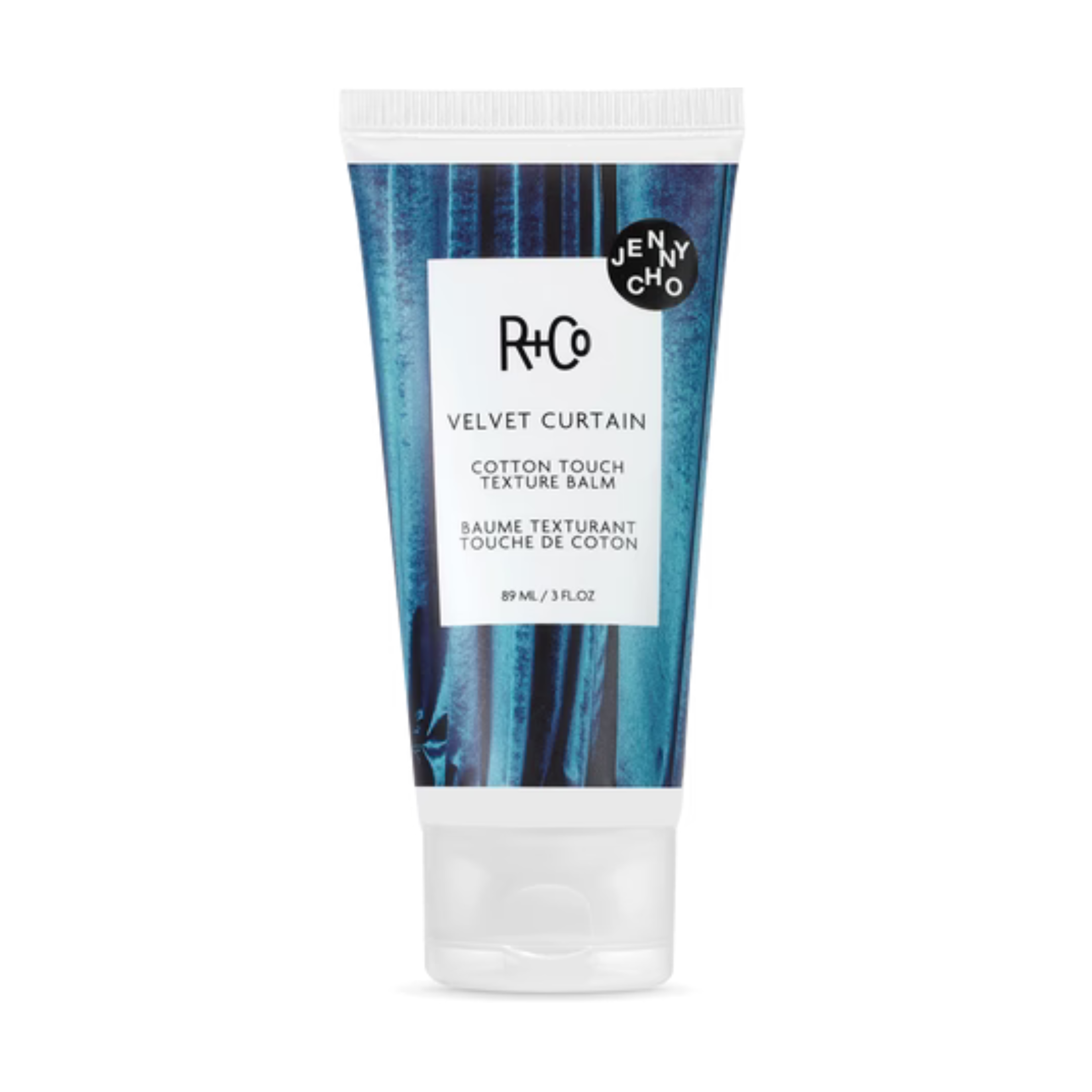 A tube of R+Co Velvet Curtain Cotton Touch Texture Balm with a blue and white design, labeled with the product name and brand.