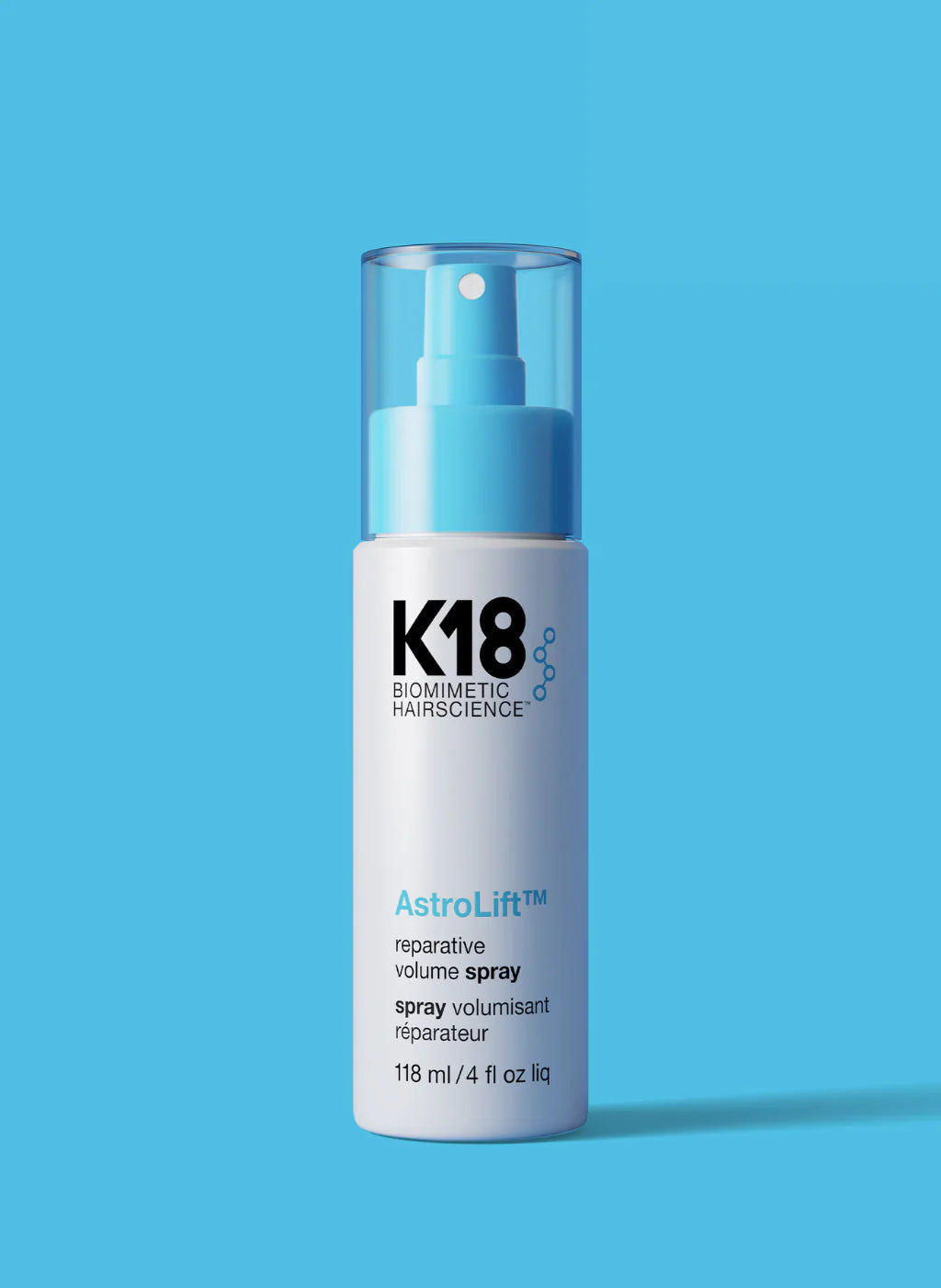 A bottle of K18 Astrolift Reparative Volume Spray against a blue background.