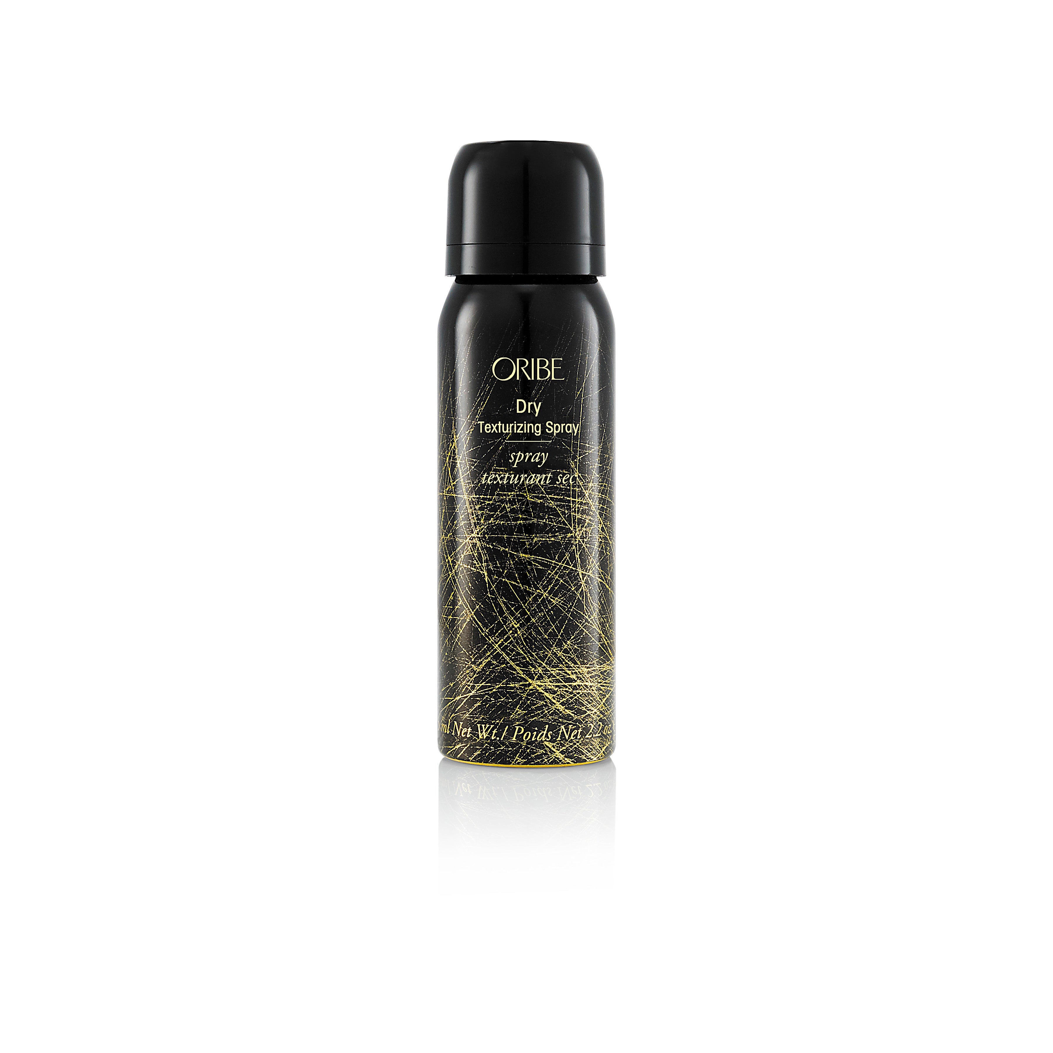 Two bottles of Oribe Dry Texturizing Spray, one larger and one smaller, with a dark label and decorative gold pattern.