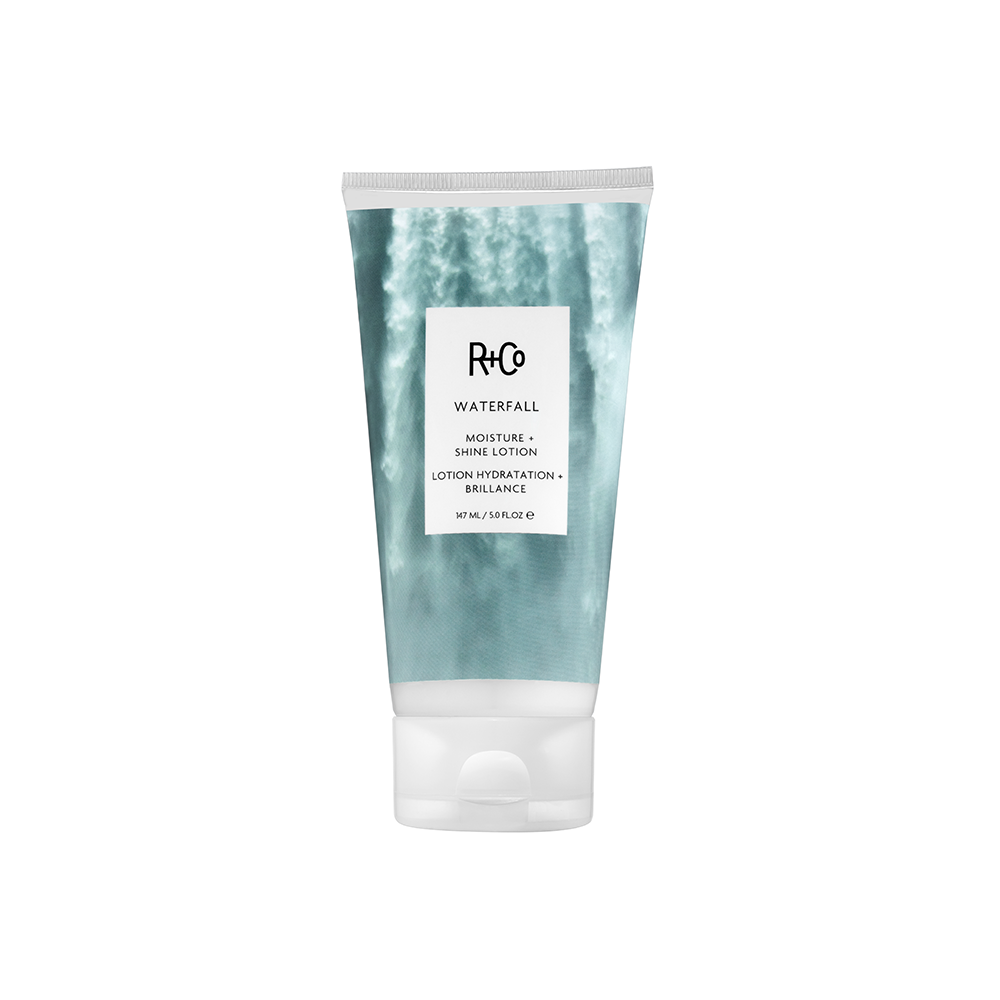 A tube of R+Co Waterfall Moisture + Shine Lotion with a blue and white label.