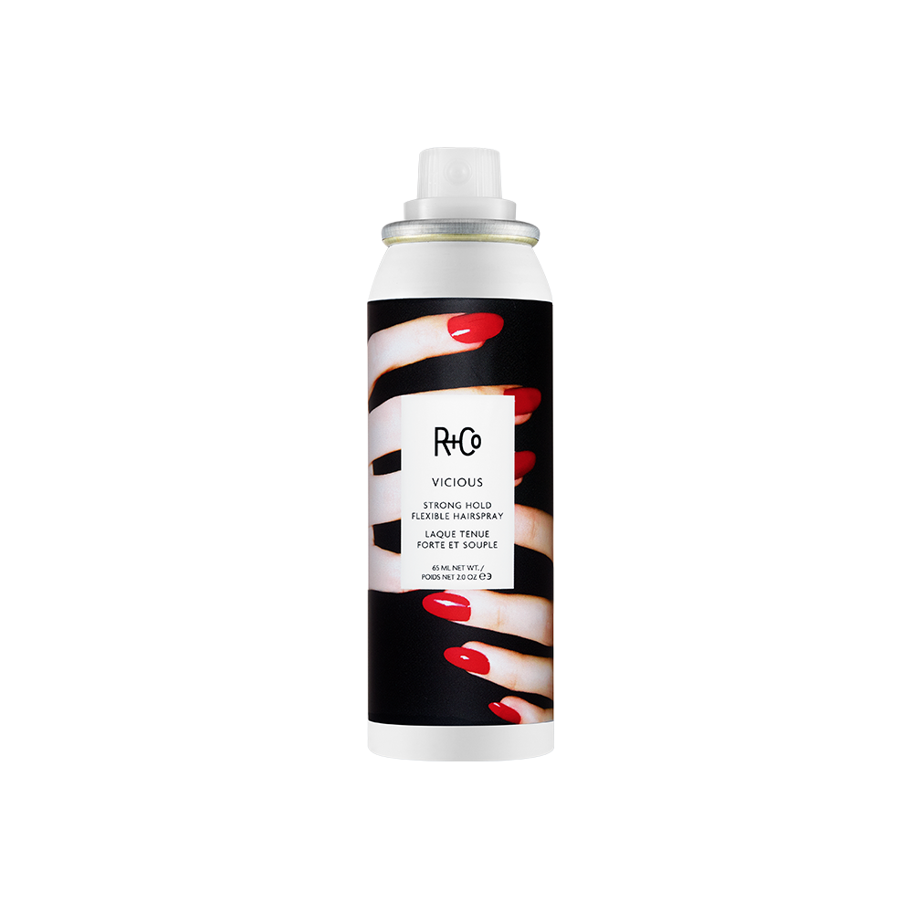 A can of R+Co Vicious strong hold flexible hair spray with a black background and white text, featuring an image of red fingernails.